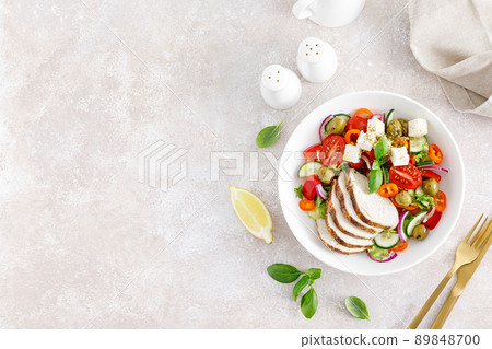 Grilled chicken breast and fresh greek salad with feta cheese. Top view 89848700