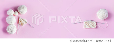 White balls of thread with knitting needles on a pink background for knitting warm clothes, banner White balls of thread with knitting needles on a pink background for knitting warm clothes, banner 89849431