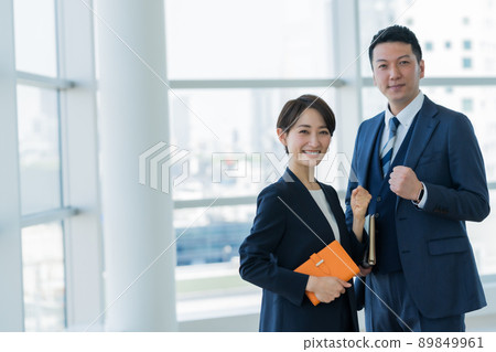A businessman with a suit that makes a guts pose 89849961