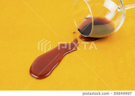 a spilled glass of wine on the tablecloth. Cleaning clothes and furniture from stains. a spilled glass of wine on the tablecloth. Cleaning clothes and furniture from stains. 89849997