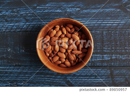 Almonds in a bowl on a blue table Almonds in a bowl on a blue table 89850957