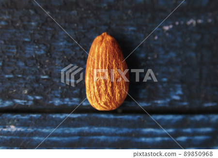 A grain of almonds on a blue table 89850968