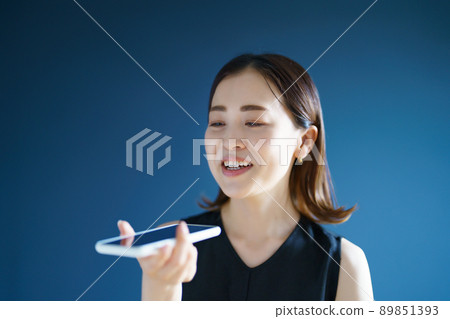 A woman talking on a smartphone A woman talking on a smartphone 89851393