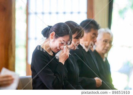 Bereaved family (female) crying at a funeral 89851910