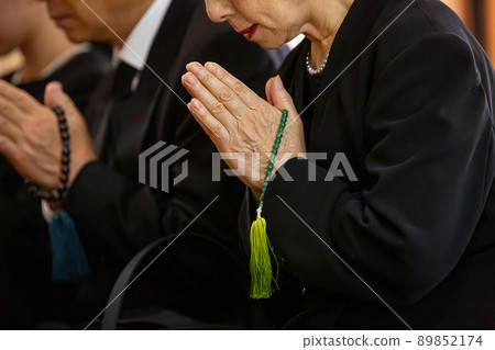 Bereaved family of mourning dress attending the funeral (no face) 89852174