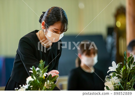 A woman in a mourning dress burning incense at a funeral A woman in a mourning dress burning incense at a funeral 89852889