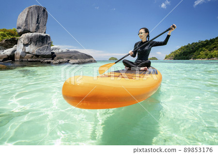 Asian woman relax on the beach with SUP BOARD 89853176