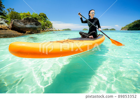 Asian woman relax on the beach with SUP BOARD 89853352