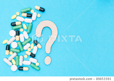Wooden question mark and different drugs with pills on a blue background. Treatment choice concept. Flat lay. Top view. Place for text. Copy space. Wooden question mark and different drugs with pills on a blue background. Treatment choice concept. Flat lay. Top view. Place for text. Copy space. 89853391