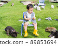 Asian cute boy Happy sitting in a chair among the bunnies. 89853694