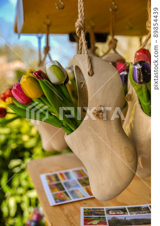 Lisse, Netherlands, April 2022. Clogs and wooden tulips, souvenirs of Holland. 89854439