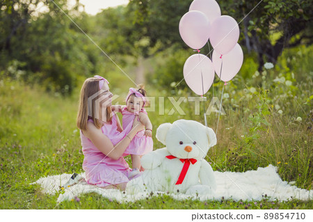 mother and daughter in pink dresses and pink balloons 89854710