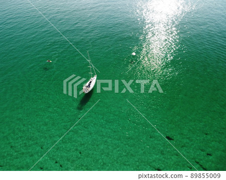 Aerial panoramic view of seascape with crystal clear azure sea and rocky shores. Yachts in a beautiful lagoon on backdrop of rocks. The concept of an ideal destination for summer travel and vacation. Aerial panoramic view of seascape with crystal clear azure sea and rocky shores. Yachts in a beautiful lagoon on backdrop of rocks. The concept of an ideal destination for summer travel and vacation. 89855009