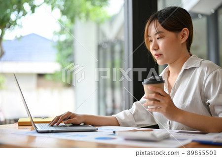 Concentrated Asian young businesswoman or female worker using laptop computer Concentrated Asian young businesswoman or female worker using laptop computer 89855501