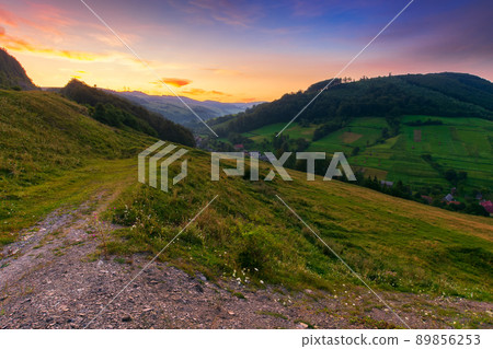 mountainous countryside landscape at dawn. rural fields on the hills. village in the distant valley. gorgeous sky with clouds glowing in morning light mountainous countryside landscape at dawn. rural fields on the hills. village in the distant valley. gorgeous sky with clouds glowing in morning light 89856253