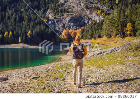 Man tourist in background of Panoramic morning view of Black Lake Crno Jezero. Calm summer scene of Durmitor Nacionalni Park, Zabljak location, Montenegro, Europe. Beauty of nature concept background 89860017
