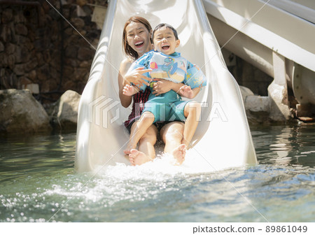 Asian boy and he mother play on the  slider water 89861049