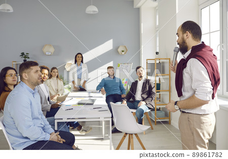 Diverse team of employees or trainees who listen to business coach at training in office. Diverse team of employees or trainees who listen to business coach at training in office. 89861782