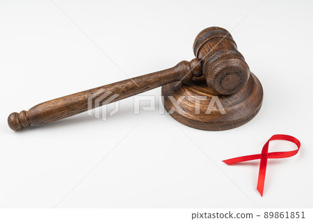 Judicial gavel and red ribbon on a white background. Symbol of the fight against AIDS. 89861851