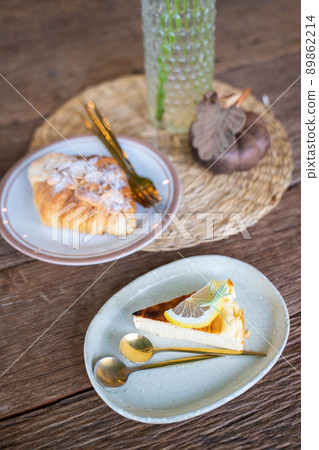 Burnt Cheesecake with sliced lemon and croissant 89862214