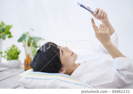 年輕女子在客廳看智慧型手機 89862232