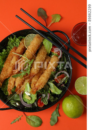 Concept  of tasty food with deep-fried shrimp on orange background 89862299