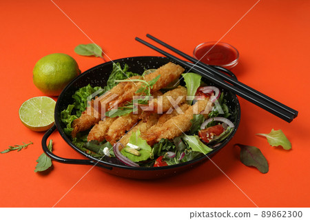 Concept of tasty food with deep-fried shrimp on orange background 89862300