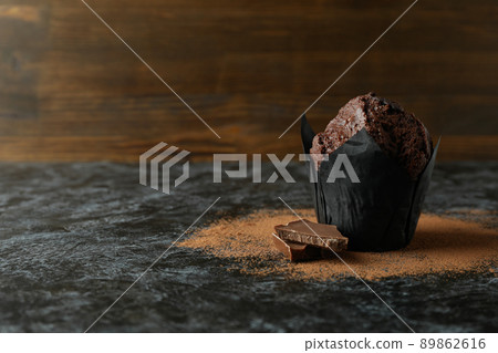 Tasty chocolate muffin on black smokey table Tasty chocolate muffin on black smokey table 89862616