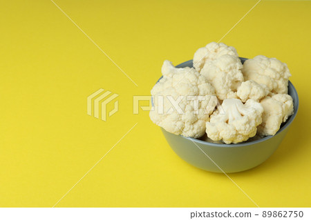 Fresh juicy cauliflower slices in bowl on yellow background Fresh juicy cauliflower slices in bowl on yellow background 89862750