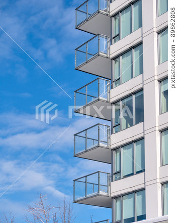 Corner of residential high rise building on blue cloudy sky background Corner of residential high rise building on blue cloudy sky background 89862808