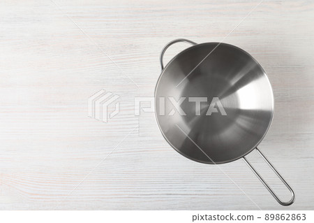 Metal bowl on white wooden background, space for text Metal bowl on white wooden background, space for text 89862863