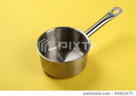 Metal empty bowl on yellow background, close up 89862875
