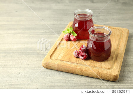 Glass jars of raspberry jam with ingredients on wooden board Glass jars of raspberry jam with ingredients on wooden board 89862974