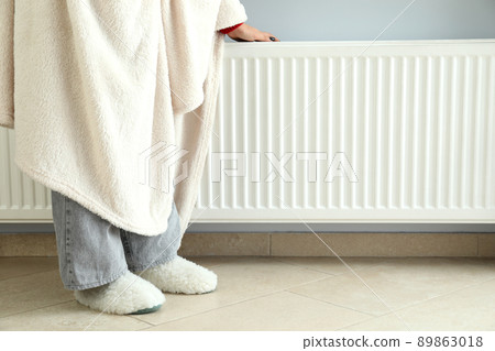 Concept of heating season with girl standing near radiator Concept of heating season with girl standing near radiator 89863018