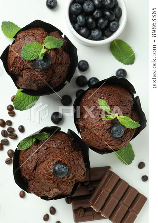Concept of delicious food with chocolate muffins on white background 89863365