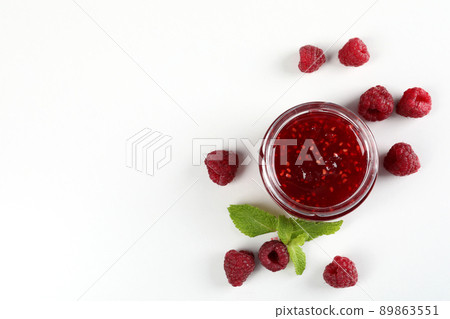 Jar of raspberry jam with ingredients on white background 89863551