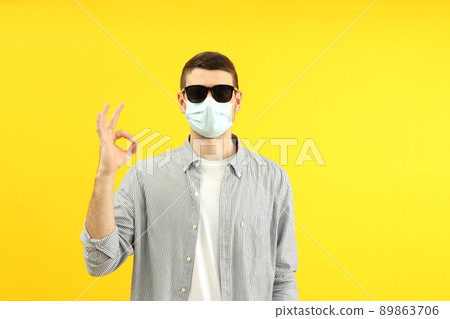 Traveling concept during coronavirus with young man on yellow background Traveling concept during coronavirus with young man on yellow background 89863706