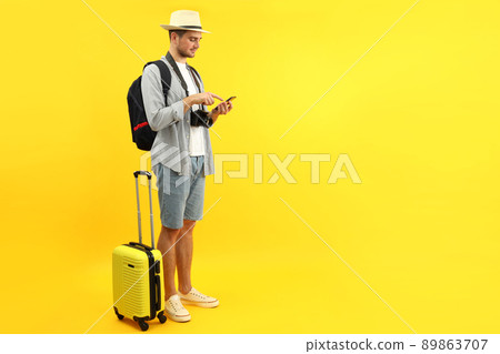 Traveling concept with young man on yellow background, space for text Traveling concept with young man on yellow background, space for text 89863707