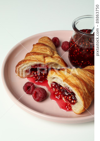 Concept of delicious food with croissant with raspberry jam on white background Concept of delicious food with croissant with raspberry jam on white background 89863750