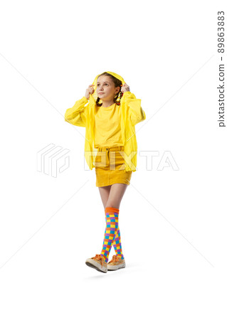Portrait of little girl wearing bright yellow outfit, posing isolated over white studio background Portrait of little girl wearing bright yellow outfit, posing isolated over white studio background 89863883