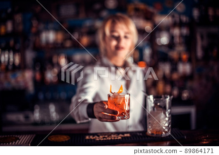 Girl barman formulates a cocktail in the taproom 89864171