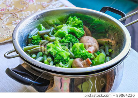 boiled green vegetables in stainless steel colander - full-frame closeup boiled green vegetables in stainless steel colander - full-frame closeup 89864220
