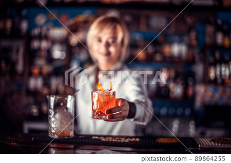 Girl barman mixes a cocktail in the alehouse Girl barman mixes a cocktail in the alehouse 89864255
