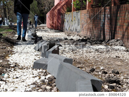Work on the device sidewalk in the city. Spring improvement in the city. Work on the device sidewalk in the city. Spring improvement in the city. 89864320