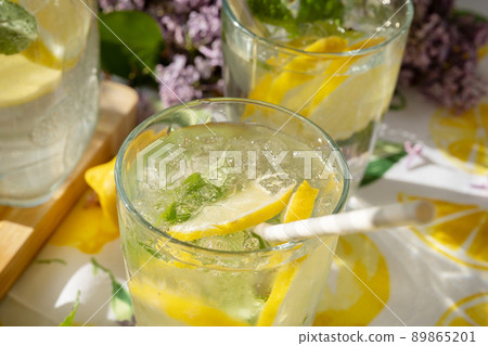 Macro shot of mouthwatering soda water with ice in a glass. Sunlight and shadows. Summer drink concept Macro shot of mouthwatering soda water with ice in a glass. Sunlight and shadows. Summer drink concept 89865201