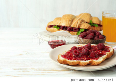 Concept of delicious food with croissants with raspberry jam on white wooden background Concept of delicious food with croissants with raspberry jam on white wooden background 89865461