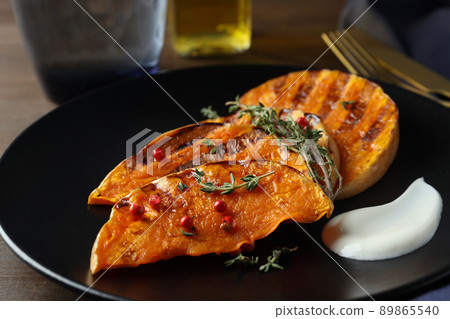 Concept of tasty eating with baked pumpkin on wooden background 89865540