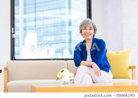 A middle-aged woman relaxing in the living room 89866140