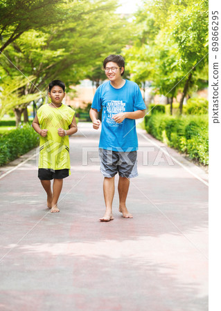Asian couple of brother run together in park. Asian couple of brother run together in park. 89866295
