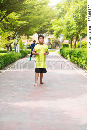 Asian man jogging at the park in sunny morning. Asian man jogging at the park in sunny morning. 89866301